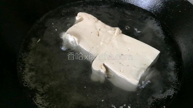 豆腐放锅里淖水。