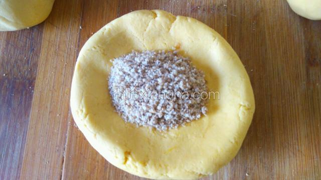 用手把剂子按成饼，加入芝麻馅