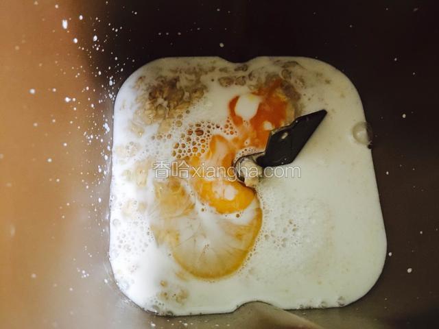 把浸泡好放凉的燕麦片倒入面包机桶内，加入一个鸡蛋。