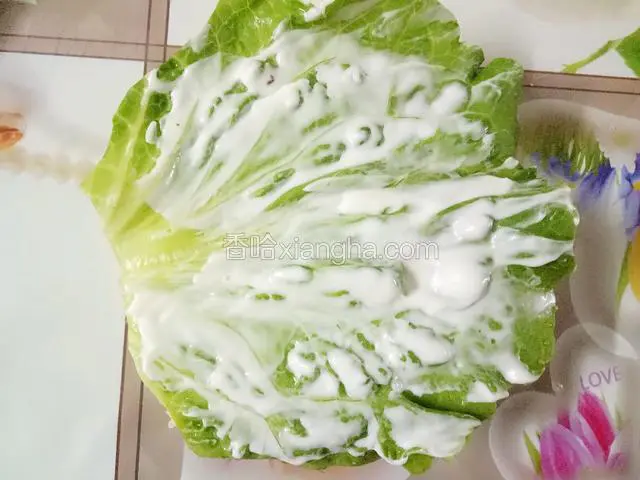 放上一片生菜叶再抹上适量沙拉酱