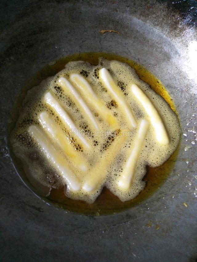 起锅倒入适量油烧6成热把控干水的年糕一条一条放入油锅（注意炸年糕时有油会炸出）