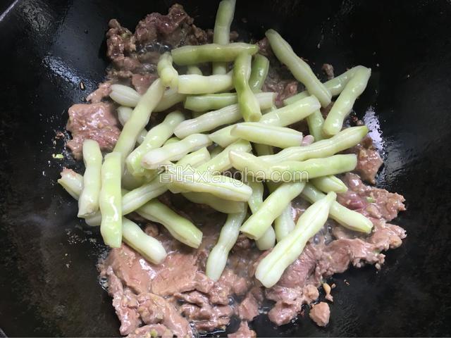 肉炒至断生后放入芸豆一起炒，炒至芸豆能用锅铲轻轻地切断。