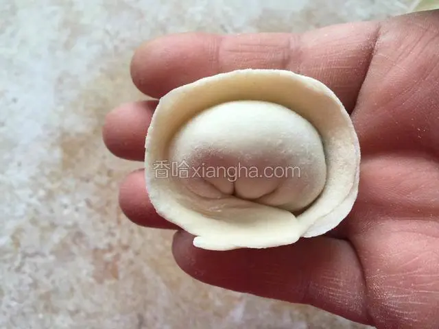 将饺子的左右两个角捏在一起即可。