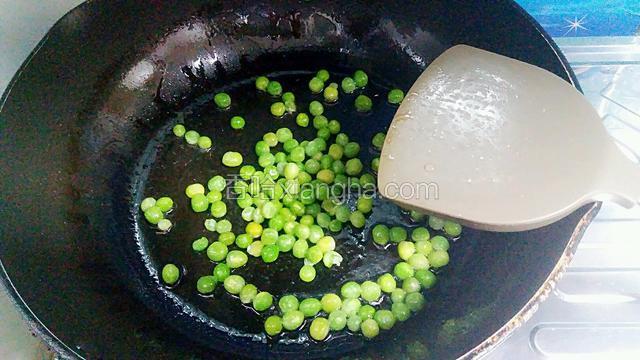 随后炒锅烧热倒一点底油，把焯水的青豆翻炒。