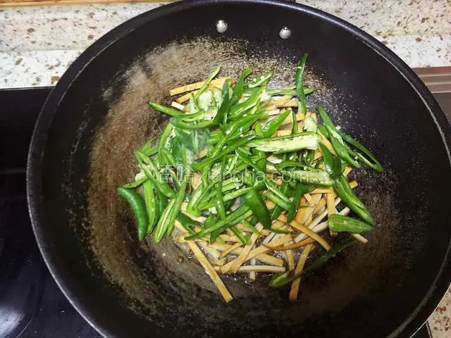 倒入青椒豆腐干快速翻炒至断生