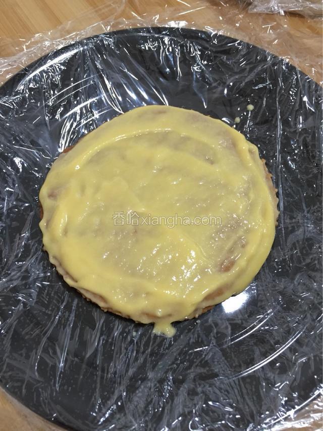 盘中铺一层保鲜膜 放一个饼皮 涂一层调制好的奶酪炼乳