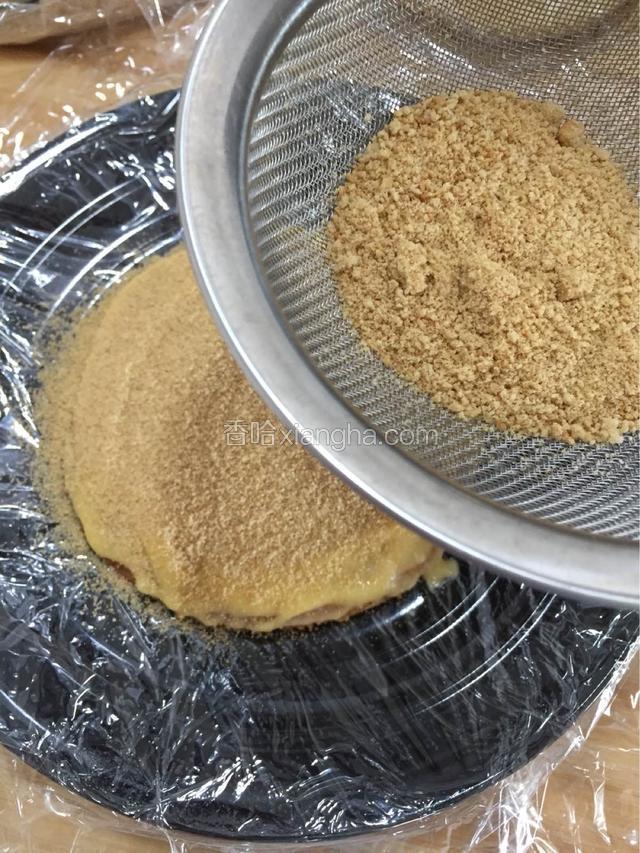 将饼碎用晒网过滤撒在涂了炼乳的面皮上