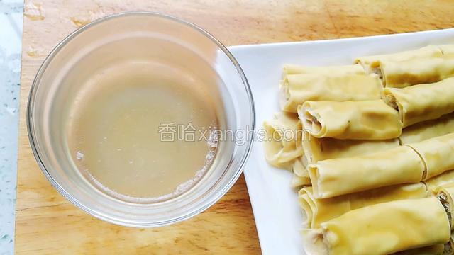 十五分钟后千张肉卷蒸好端出，把蒸的汁从盘子里倒出来。