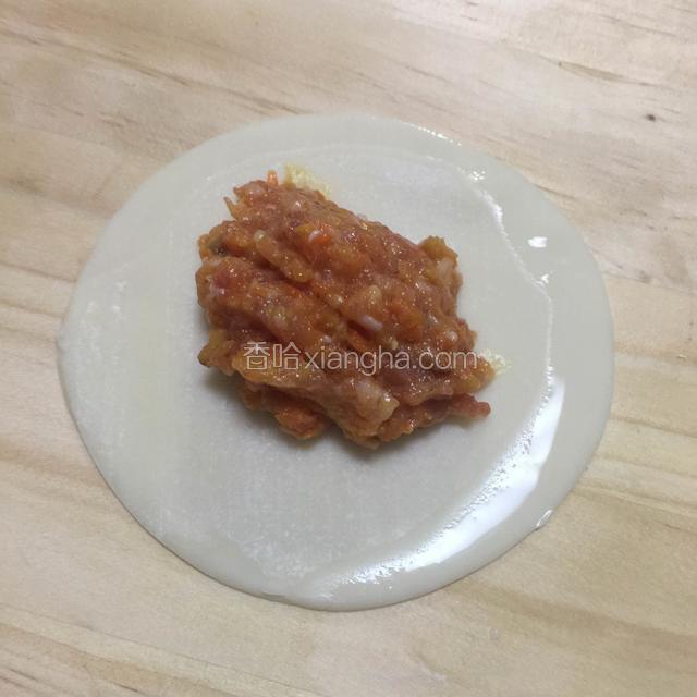 一小勺肉末放在饺皮上