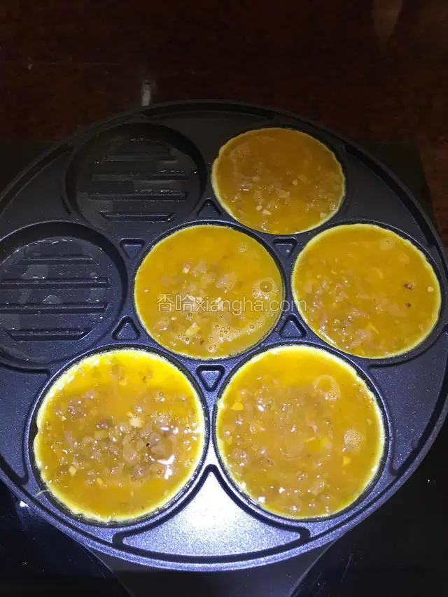舀入菜脯蛋液，可以适当调小火煎。