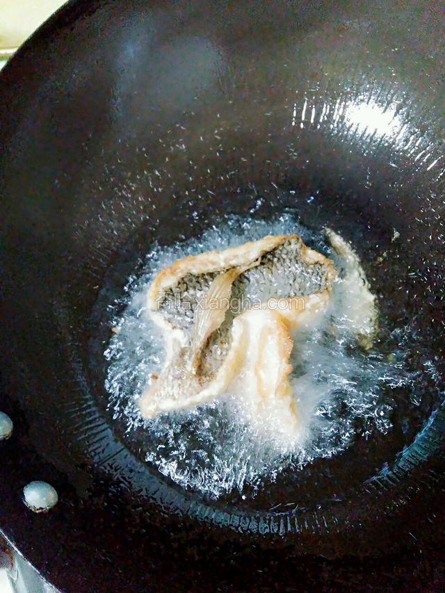 锅里倒入适量的油。油温八成热时将鱼放入。鱼皮朝上。
