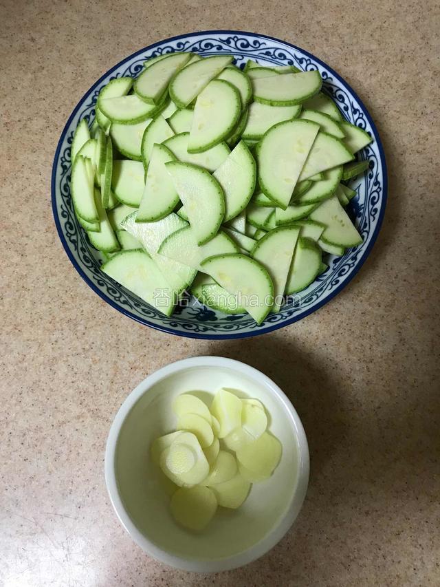 西葫芦对剖成两，然后切稍厚的半圆片，蒜切片备用