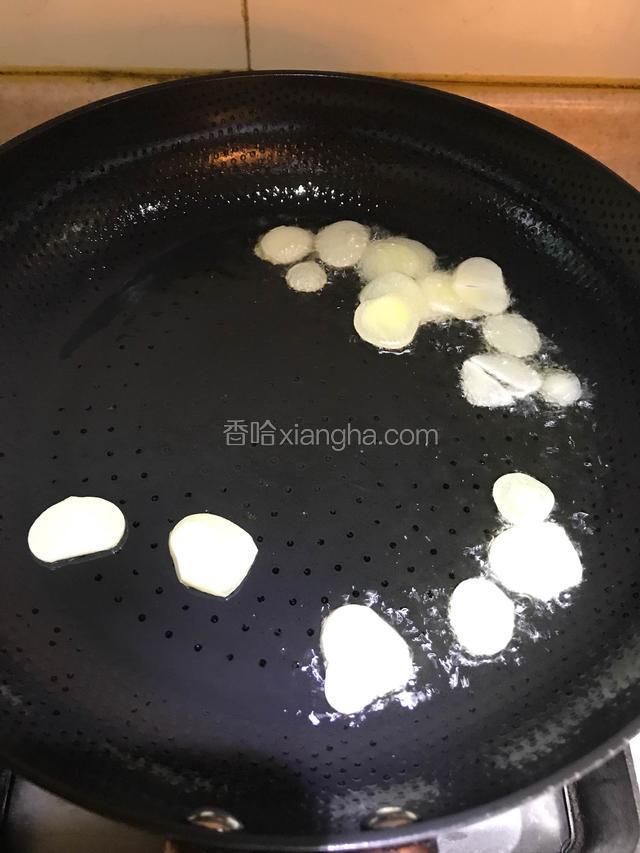 锅内倒入适量的油，油温五成热放入蒜片爆香