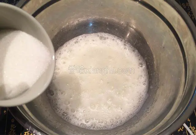在蛋白盆里加几滴柠檬汁，用电动打蛋器低速搅打至蛋白泡沫呈鱼泡眼状时，加入1/3细砂糖；