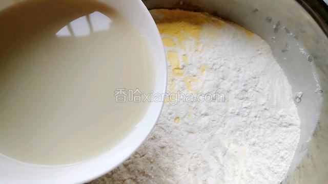 面粉和玉米粉倒在盆里，倒入酵母水。