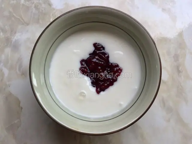 自制酸奶加入覆盆子果酱，你也可以加入其它的果酱。