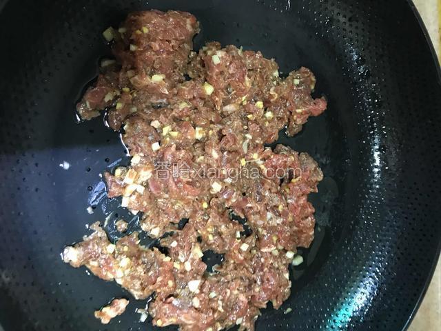 冷锅冷油下拌匀的牛肉，开中火炒散