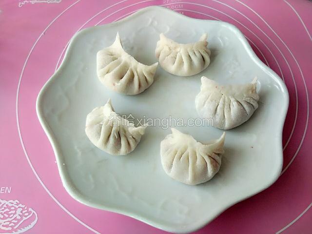 把面团分好均匀的面剂子，擀成饺子皮，放入馅料，捏成下图中饺子的形状。