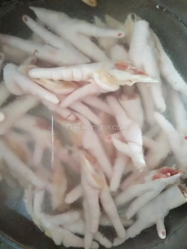清水放入鸡爪姜片，少许料酒，大火煮开后调小火煮10分钟，捞起来放入事先晾凉的凉白开中备用