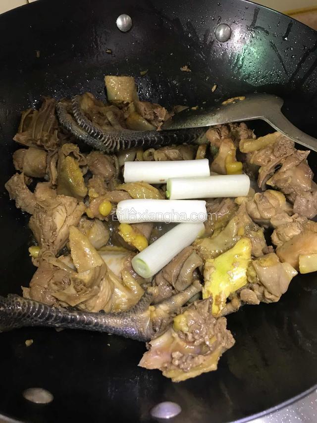 倒入鸡肉翻炒，直至鸡肉开始出油下葱段