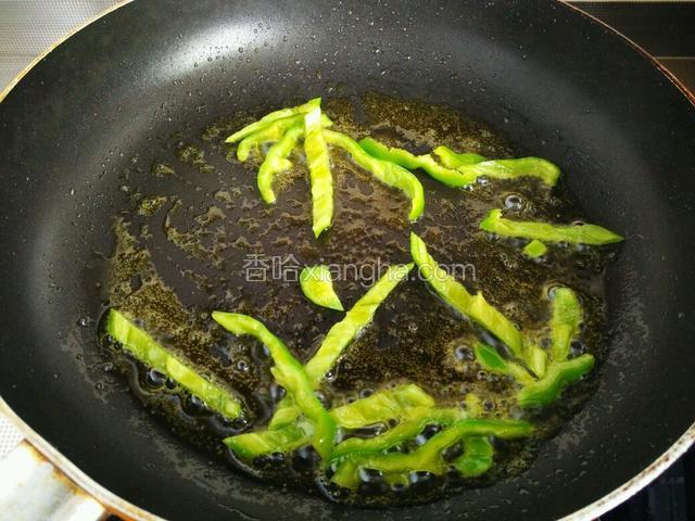 锅中倒入适量食用油，油可以稍多些，后面还要炸鸡蛋。先将青椒煸炒数下，不用炒太久，青椒变绿就可以盛出来。