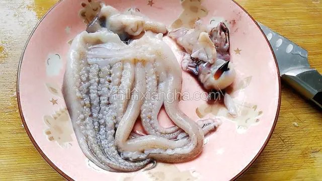 鱿鱼用剪刀从中间剪开，除去眼睛和嘴巴。