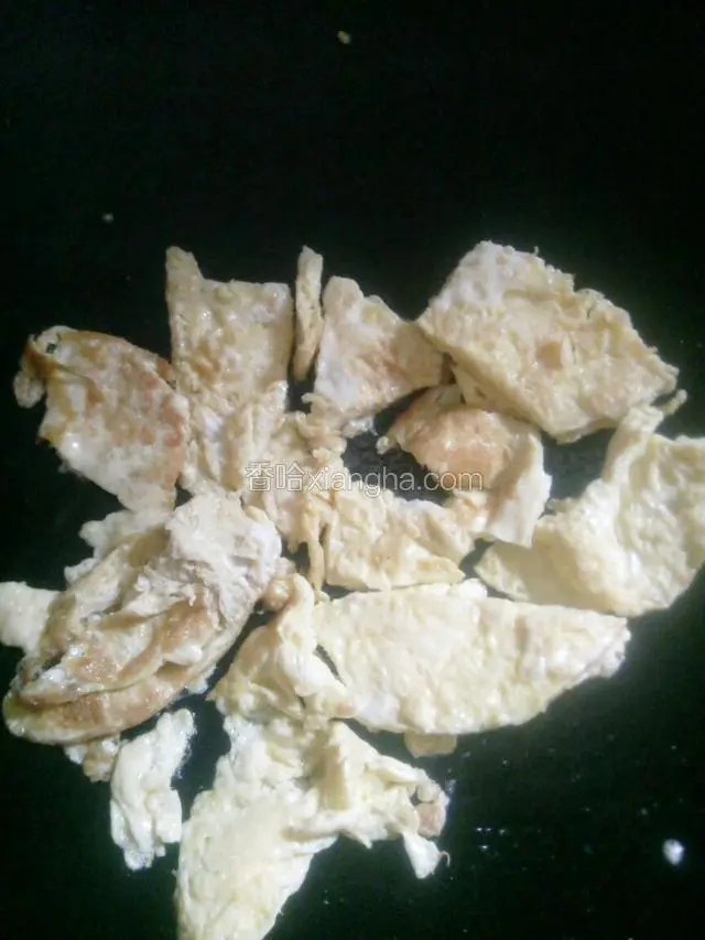 锅热油，下鸡蛋煎熟，用铲子铲小块。