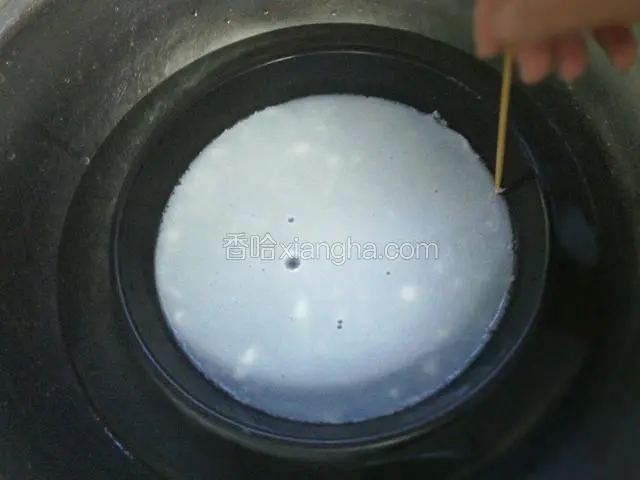 把披萨盘取出置于冷水盆中，用竹签沿着盘边划一圈，用手轻轻揭起已经凝固的粉皮。