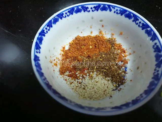 现在再说说油辣子怎么做，先把辣椒粉、花椒粉、芝麻、少许盐放入碗中。