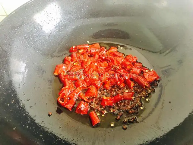 锅中留比炒菜多些的底油，关火待油温转低后放入干辣椒和花椒粒炒香。