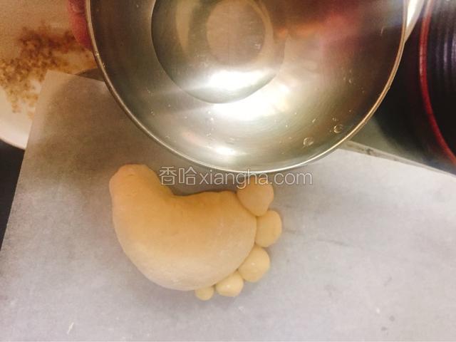 烤盘铺吸油纸，把脚掌放上去，再拿一碗清水帮助脚趾头粘在脚掌上