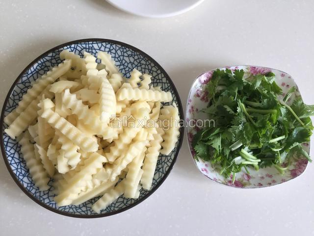 用切菜器把土豆切成狼牙条状，香菜切段。