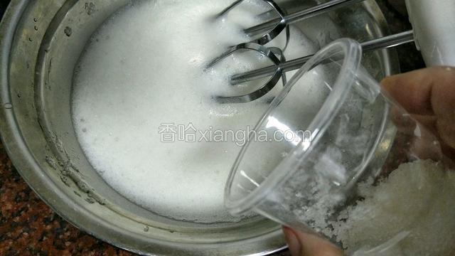 大概1分钟后表面浮起更多更白的更细小的泡沫时再加入1/3的糖继续搅打
