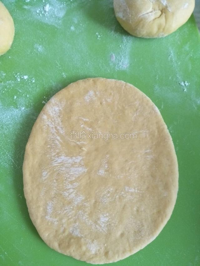 取一块黄色面团擀成椭圆形