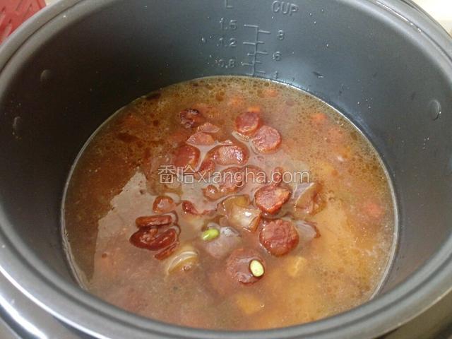 把炒好的食材倒入电饭煲中。