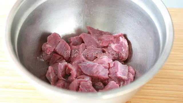 把切成块的牛肉放入料理盆中，加入柠檬汁