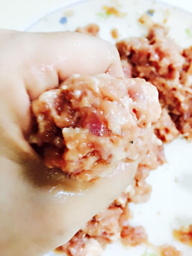 腌好的肉碎顺时针搅拌起胶，再用虎口揉成肉丸子。