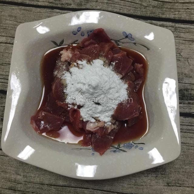 牛肉切薄片加淀粉、一勺生抽、两勺料酒，白胡椒粉，少许清水，不停的搅拌让水完全吃进肉里，然后腌制十分钟左右