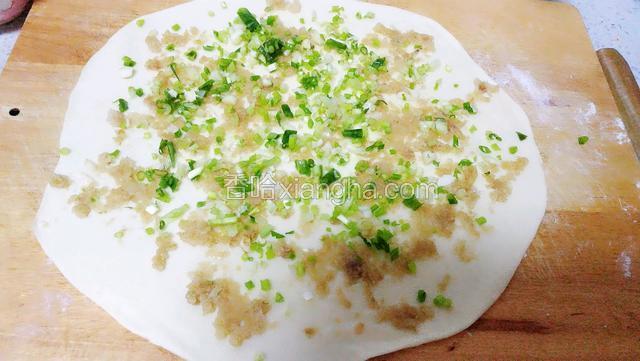再放入油渣，用勺背摊匀。撒上葱花。