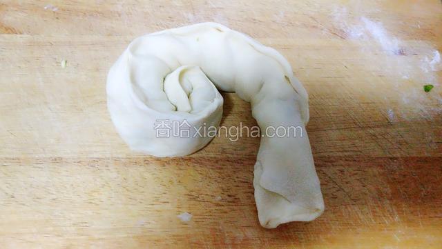 从长条的一端再卷起来。