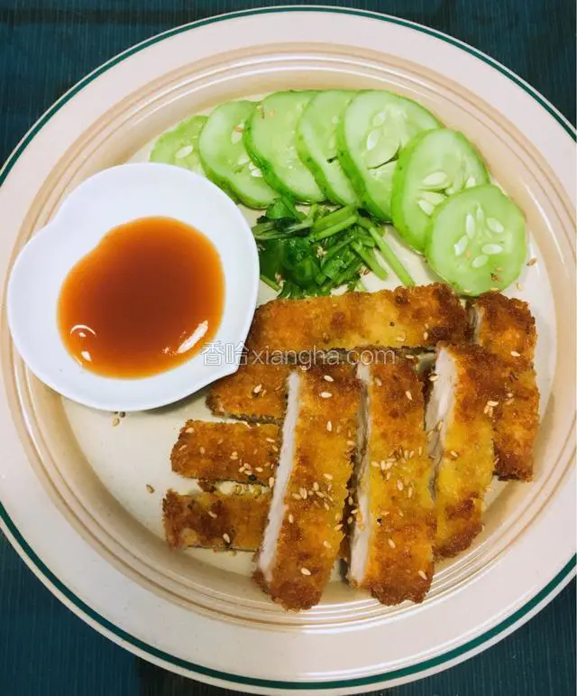 炸好的猪排切成条摆放在盘子里，码上酸甜黄瓜和猪排酱即可。