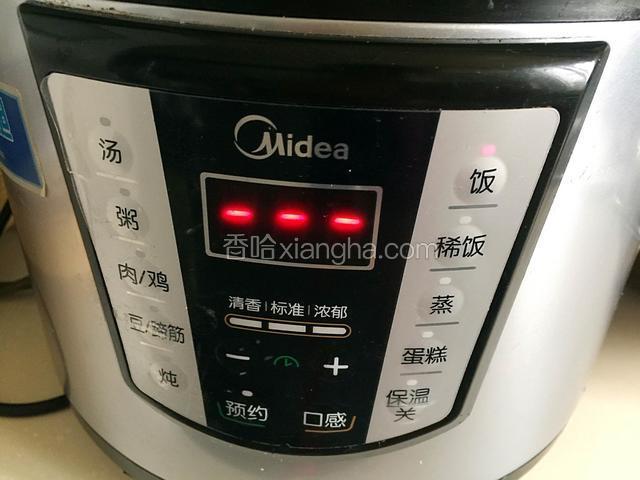 按煮饭键，煮好后将鸡翻面再次按煮饭键。