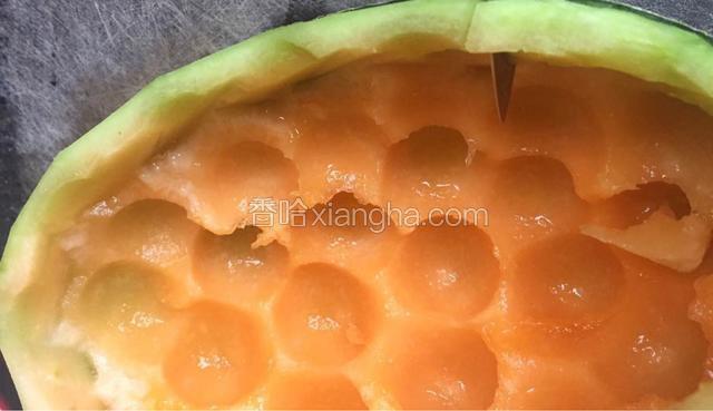 采用左一刀右一刀的刀法将削去外皮的哈密瓜皮层部分切成牙齿形状