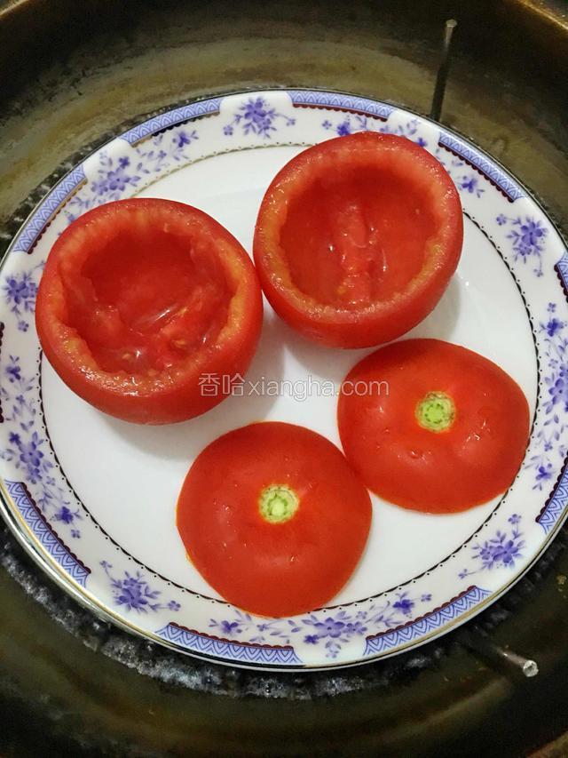 用刀把西红柿的果肉挖去，留下空心的.然后放入锅中蒸3分钟，熟透后取出。