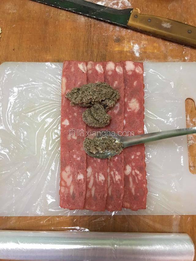 然后保鲜膜垫底，铺好培根，每片要压另一片一些边，把晾凉的蘑菇蓉放在上面