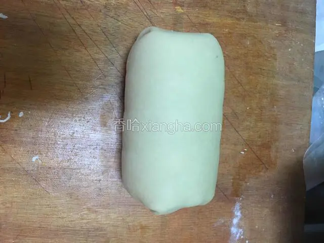 然后取出再卷上酥皮，把两边多余的酥皮切掉，上面的多留一点往下卷，压在整个牛排的下面，包裹紧致就可以了