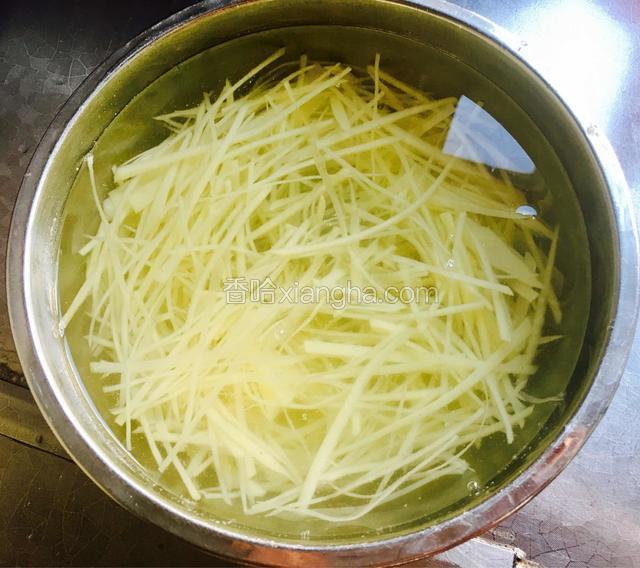 将土豆切成丝放入清水中漂洗几次，去除淀粉把土豆丝浸泡在清水中备用。