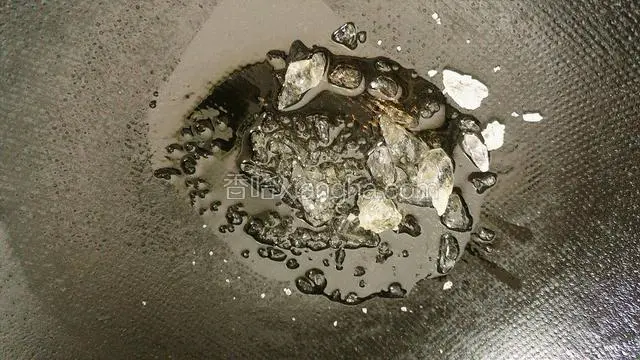 锅里放入老冰糖加花生油，小火熬制