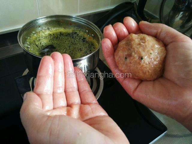 锅中倒入适量油，油最好多一些，能没过肉圆。手上抹一些油。将肉圆在手掌中来回摔打几次，同时将肉圆整整形。