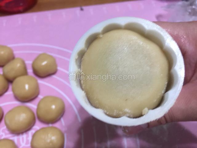 把面团轻轻的按进月饼模具里。